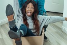 Man Pushing Woman Inside a Box